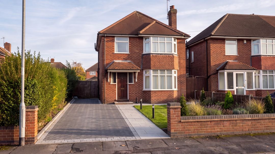 After concept: the same house with a herringbone block-paved drive, granite sett border, porcelain path, rebuilt front wall and new planting.